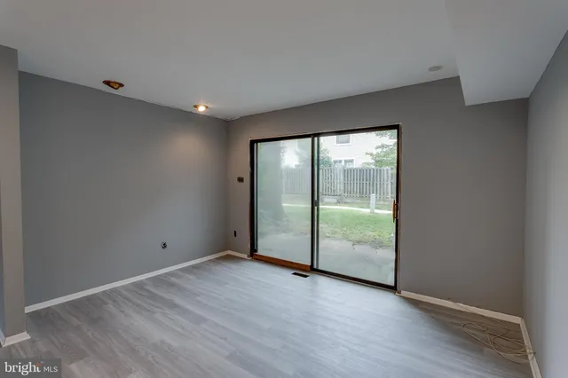 an empty room with wooden floor and sliding door
