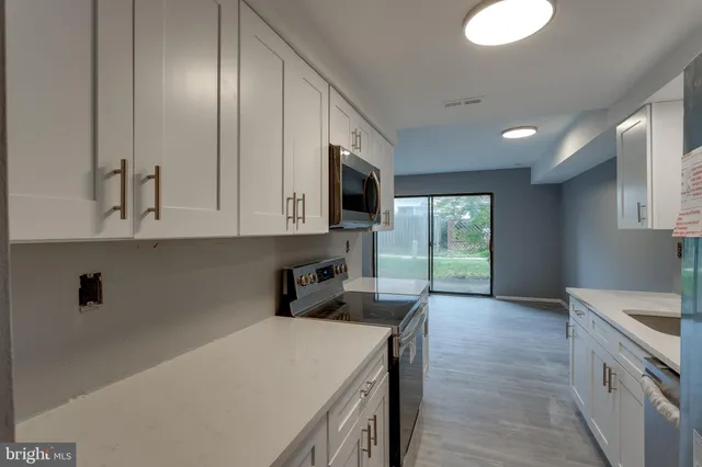 a kitchen that has a microwave a sink and a stove in it