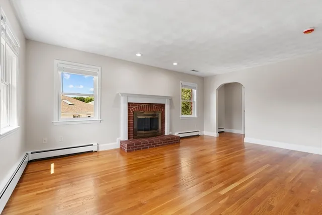 an empty room with floor to ceiling window and fireplace