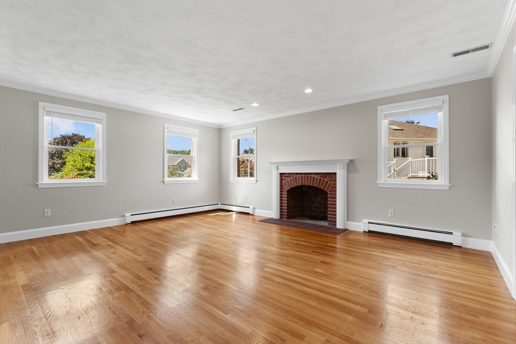 4 Gavin Circle Stoneham, MA 02180 - Photo 7 of 22 a view of an empty room with wooden floor and a window