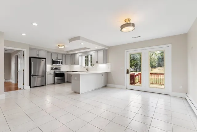 a large white kitchen with a stove a sink dishwasher and a refrigerator