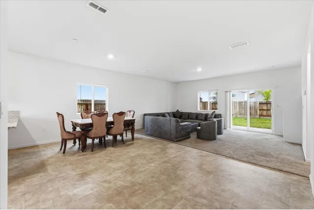 a large room with lots of tables a large window and furniture