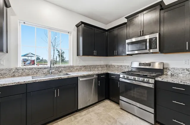 a kitchen with stainless steel appliances granite countertop a stove and a microwave
