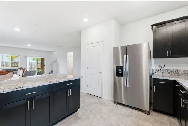 a kitchen with stainless steel appliances granite countertop a refrigerator and a sink