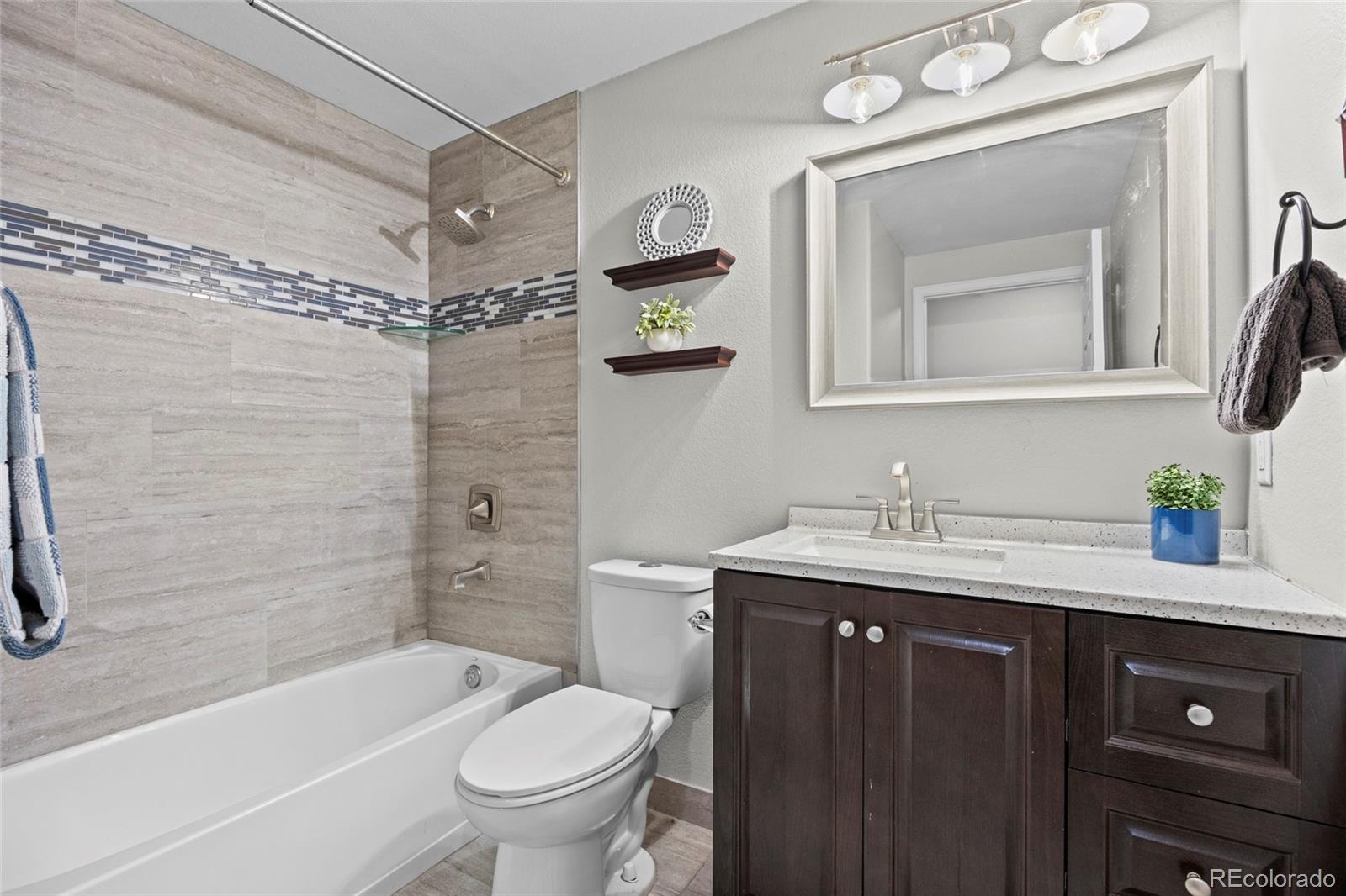 10805 Twenty Mile Road, Unit 104 Parker, CO 80134 - Photo 21 of 43 a bathroom with a granite countertop sink toilet and shower