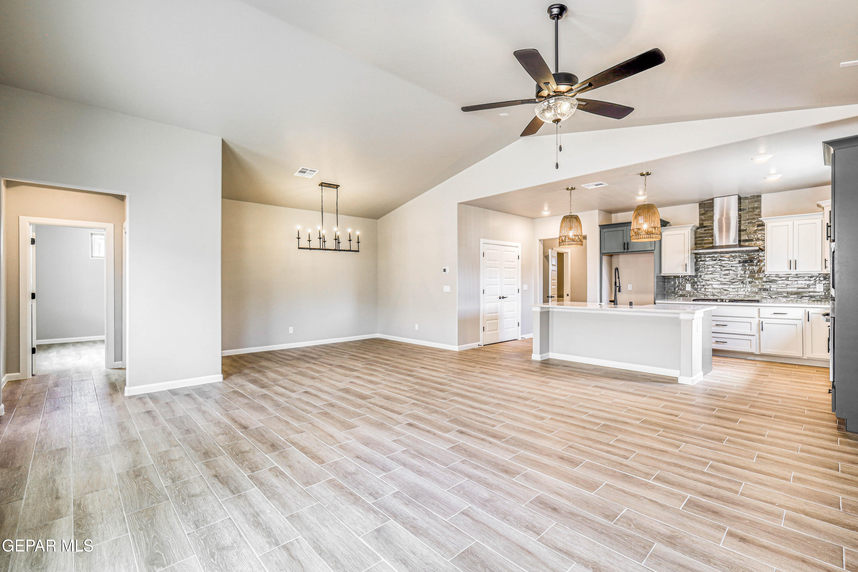 6047 Zinc Hill Street Sunland Park, NM 88008 - Photo 12 of 18 a view of a kitchen with wooden floor and a ceiling fan