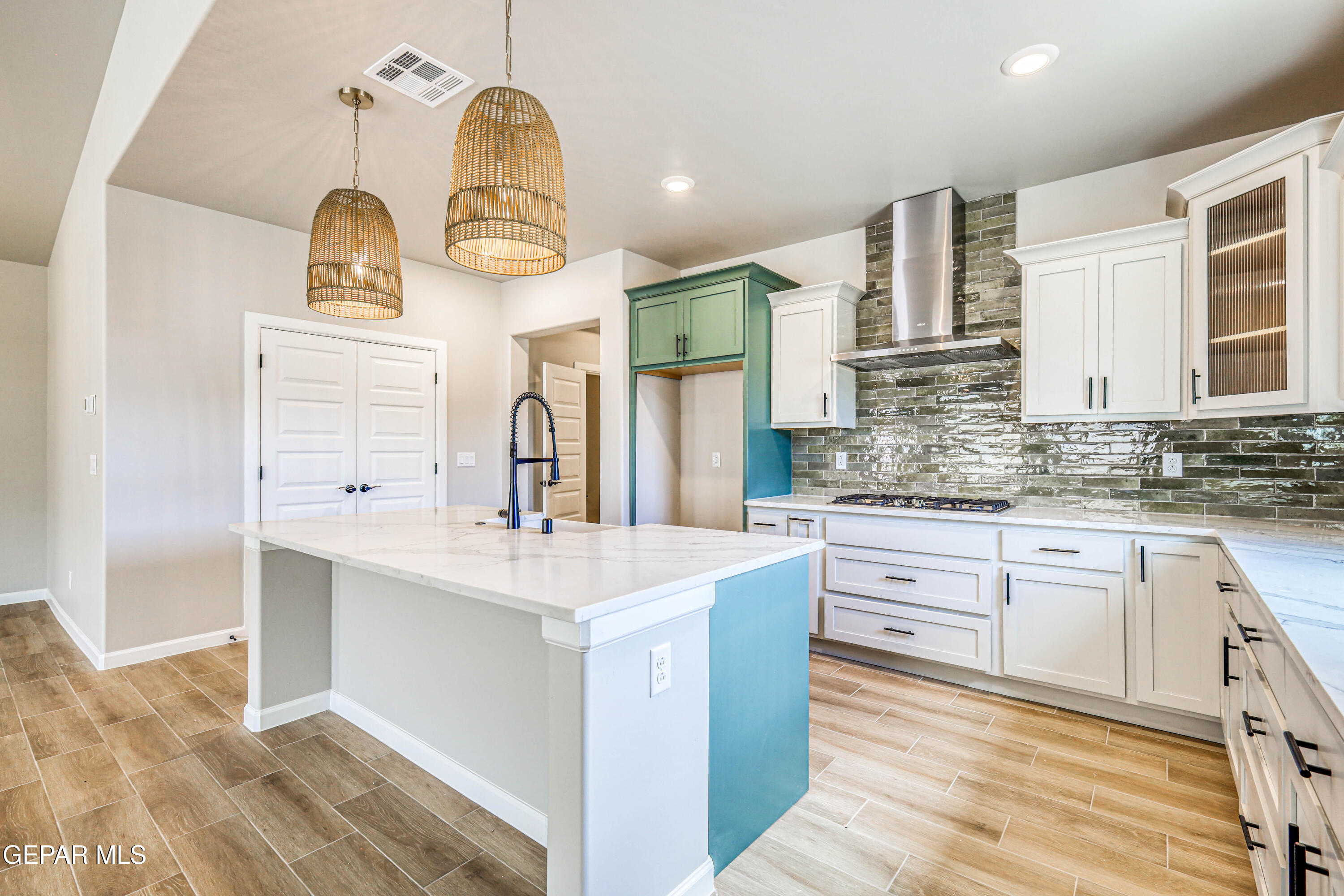 6047 Zinc Hill Street Sunland Park, NM 88008 - Photo 3 of 18 a kitchen with a sink dishwasher a stove and white cabinets with wooden floor