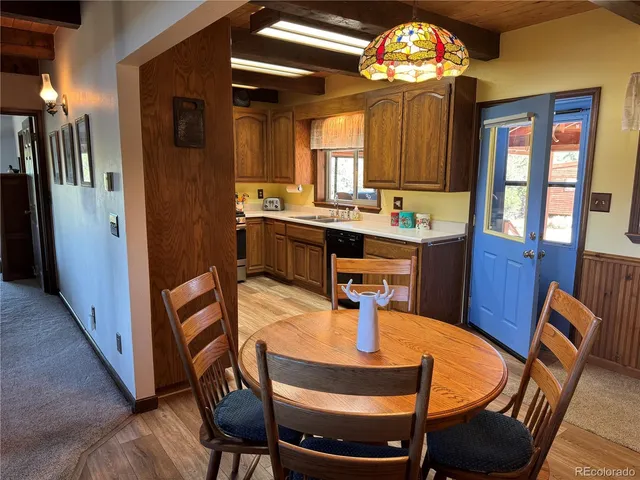 a view of a dining room with furniture a chandelier and wooden floor