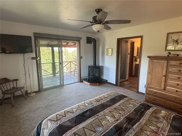 a spacious bedroom with a bed a flat screen tv and a large window