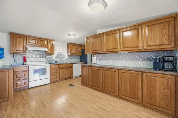 a kitchen with stainless steel appliances granite countertop a stove sink and cabinets