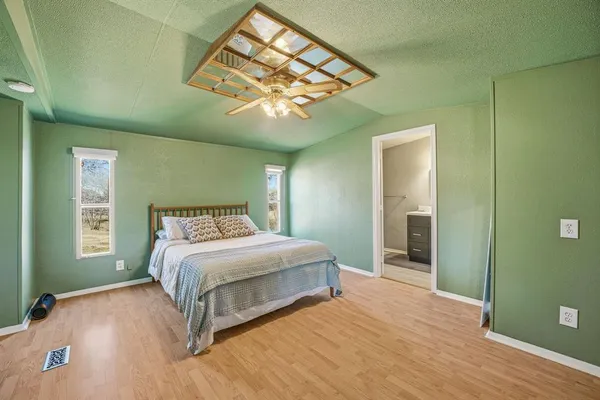 a bedroom with a large bed chandelier and a window