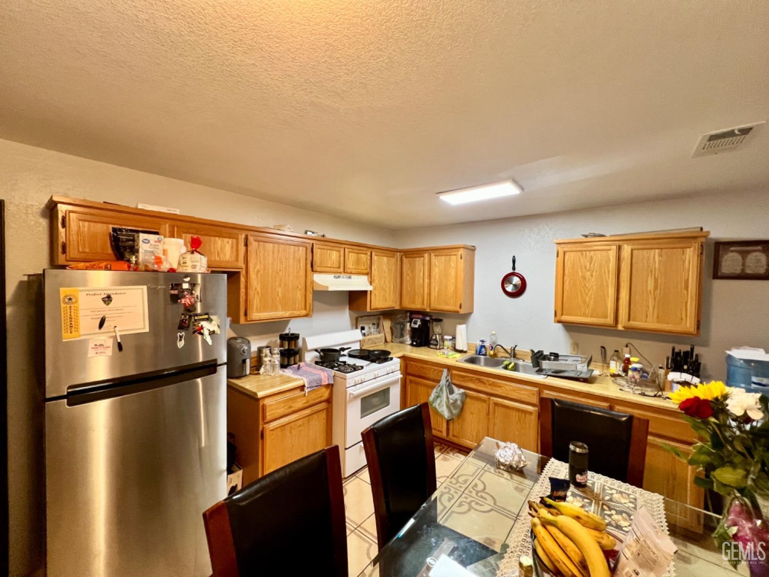 Undisclosed Address Lost Hills, CA 93249 - Photo 3 of 10 a kitchen with stainless steel appliances a refrigerator a sink a stove and cabinets