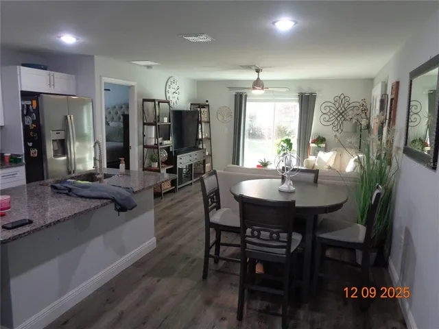 a kitchen with stainless steel appliances granite countertop a sink dishwasher a stove a refrigerator a microwave oven with a dining table and chairs