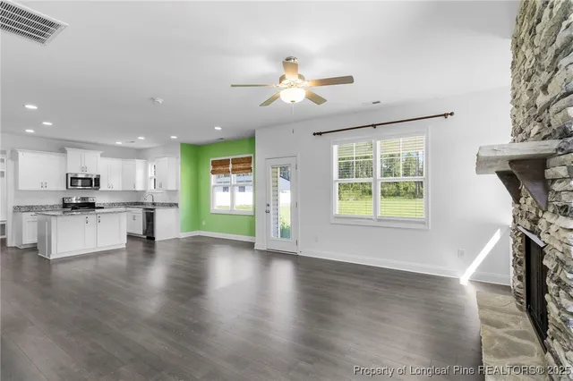 a living room with a fireplace and wooden floor
