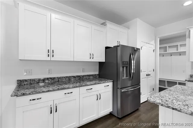 a kitchen with stainless steel appliances granite countertop a stove a microwave and a white cabinets