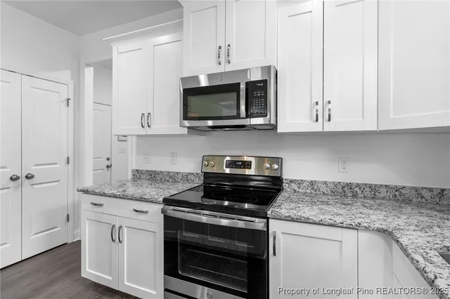 a kitchen with stainless steel appliances granite countertop a sink and a window