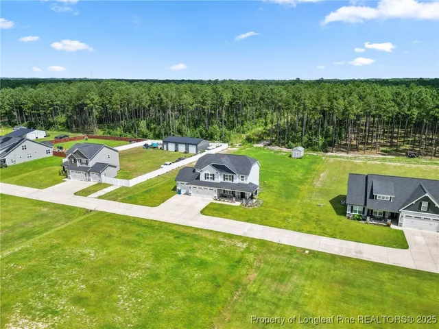 a view of a house with a big yard and large trees