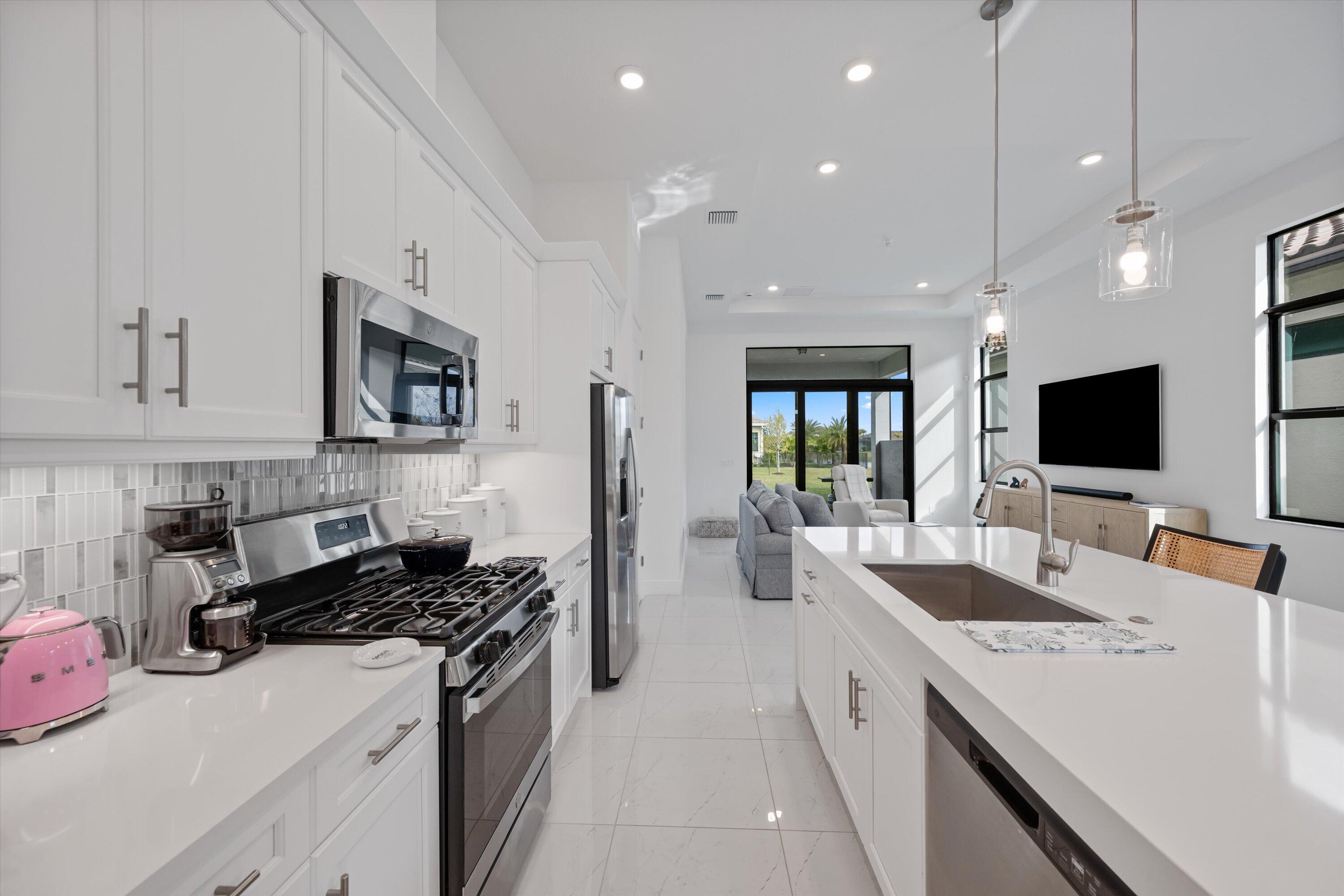4891 Rivo Alto Circle Loxahatchee, FL 33470 - Photo 12 of 64 a large white kitchen with a stove and a sink