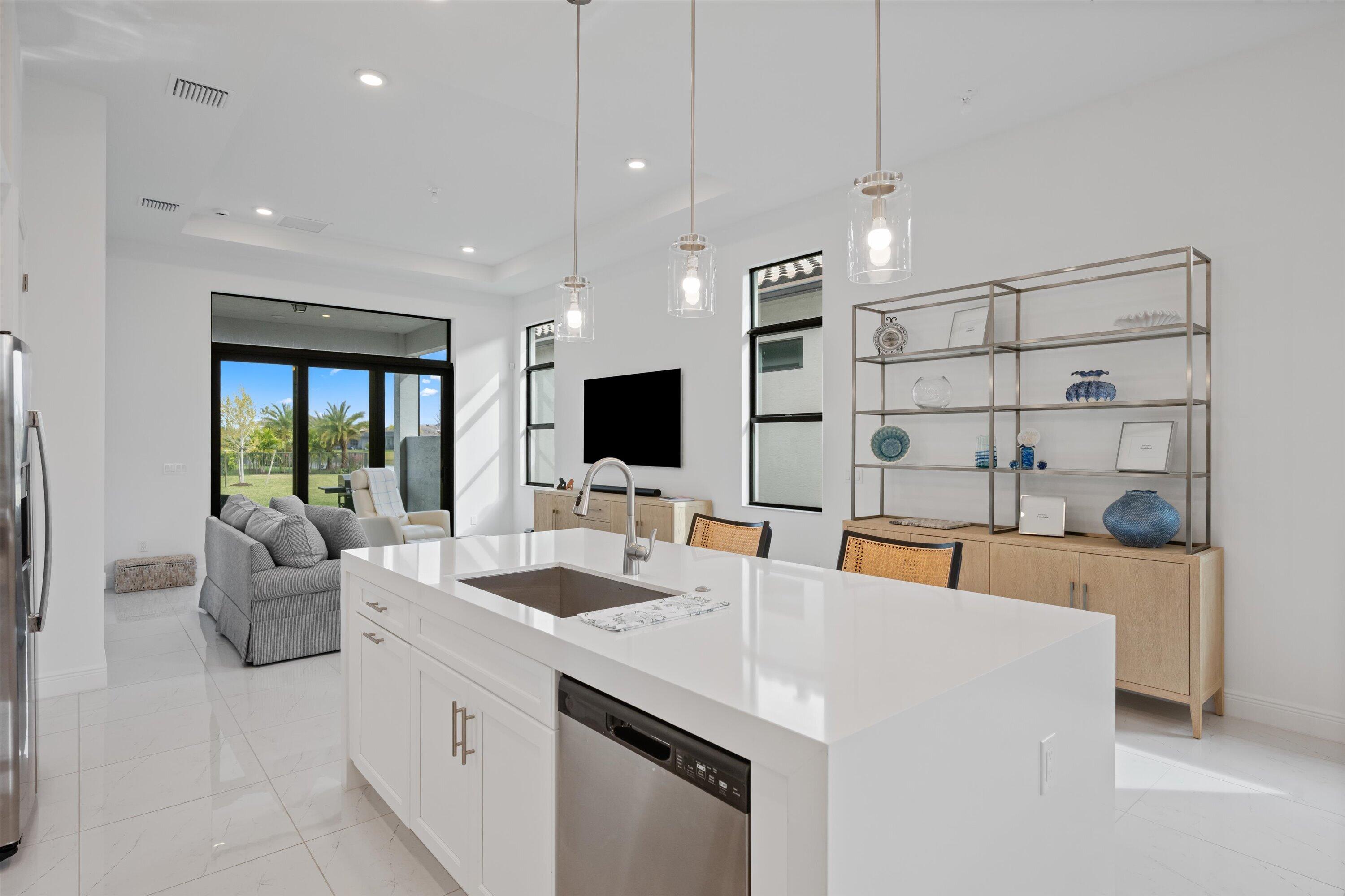 4891 Rivo Alto Circle Loxahatchee, FL 33470 - Photo 13 of 64 a large white kitchen with a large island