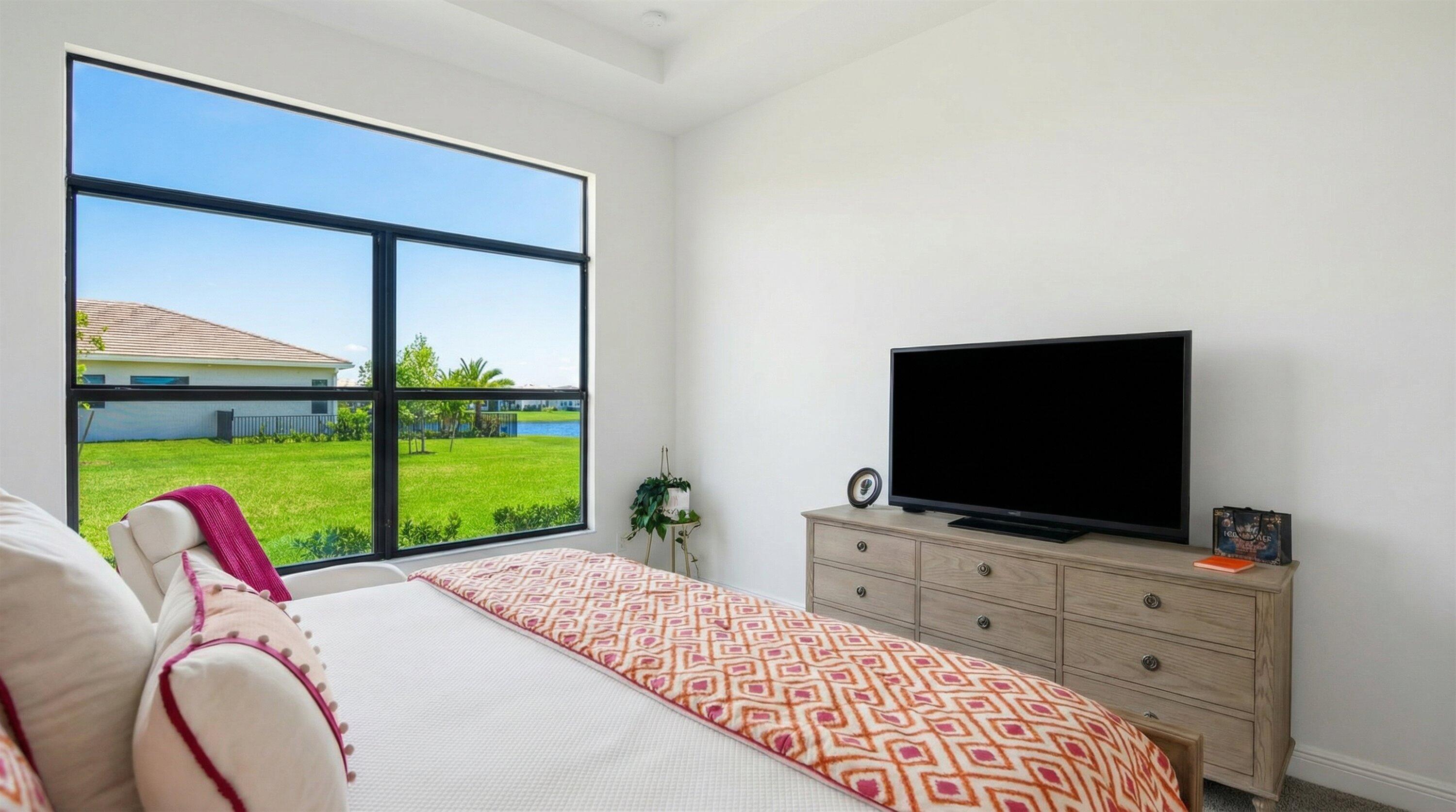 4891 Rivo Alto Circle Loxahatchee, FL 33470 - Photo 17 of 64 a bedroom with a bed and a flat screen tv