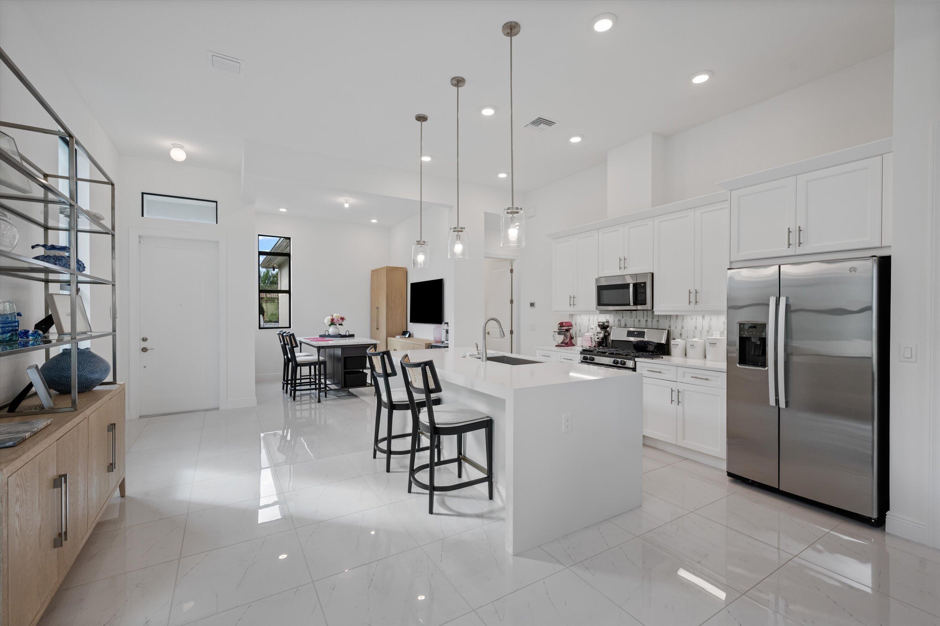4891 Rivo Alto Circle Loxahatchee, FL 33470 - Photo 10 of 64 a kitchen with refrigerator and chairs