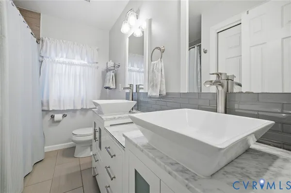 a bathroom with a granite countertop sink a toilet and a mirror