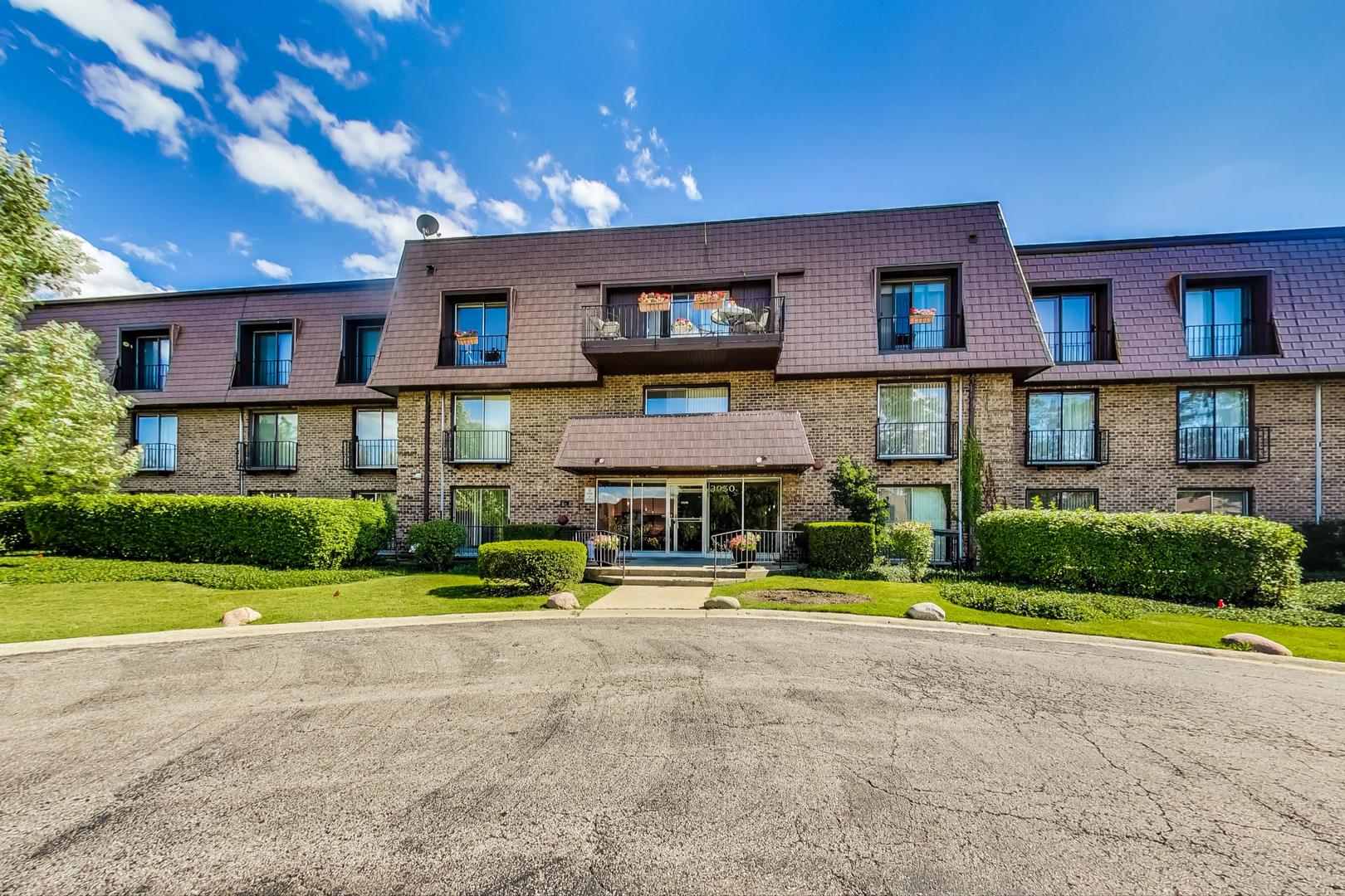 3900 Dundee Road, Unit 104 Northbrook, IL 60062 - Photo 1 of 34 a front view of a building with a garden and plants