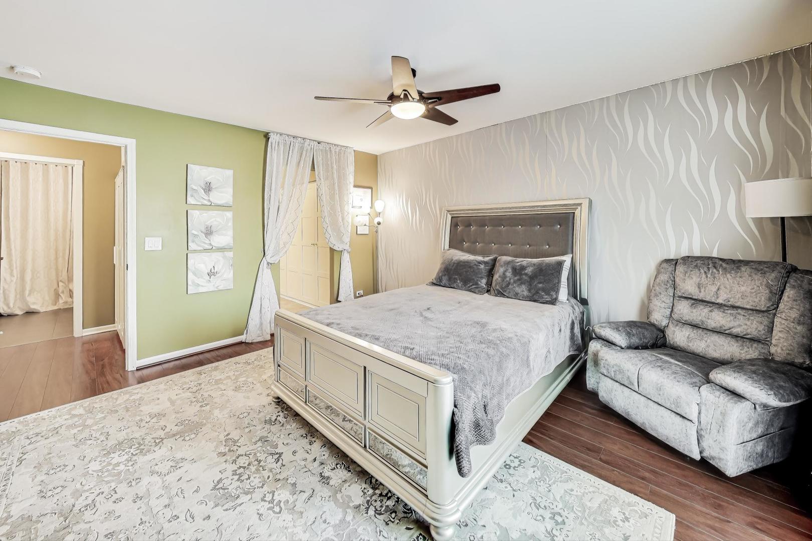 3900 Dundee Road, Unit 104 Northbrook, IL 60062 - Photo 18 of 34 a spacious bedroom with a bed and a couch