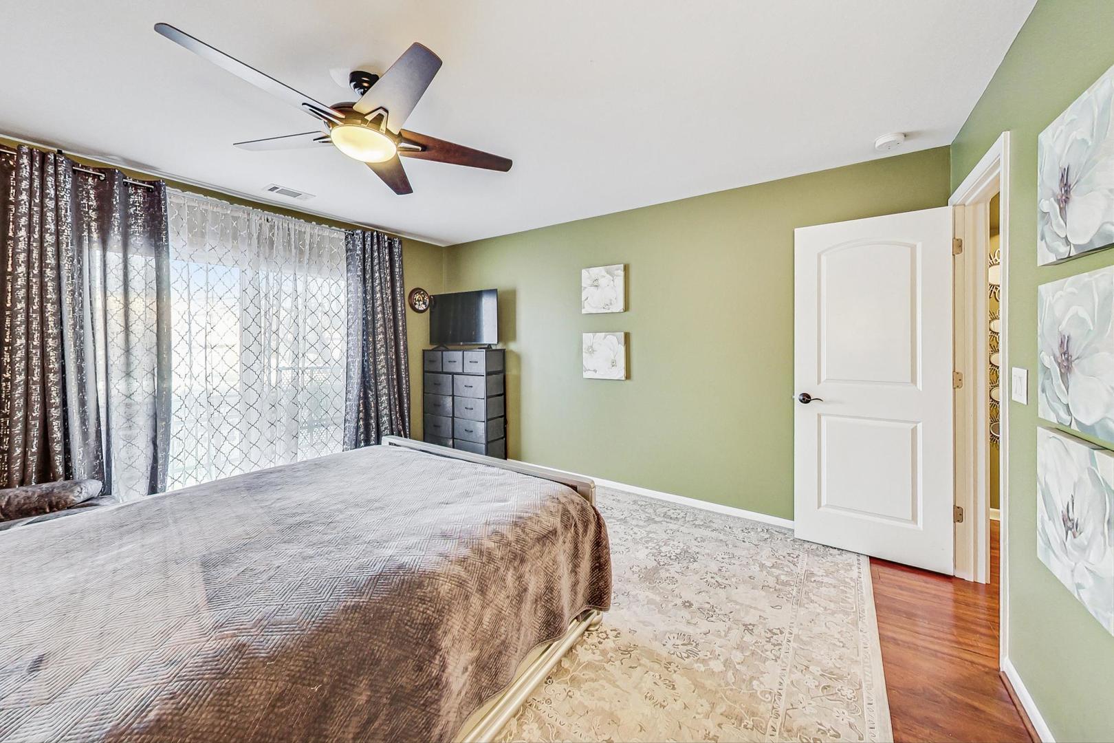3900 Dundee Road, Unit 104 Northbrook, IL 60062 - Photo 20 of 34 a bedroom with a bed and a chandelier