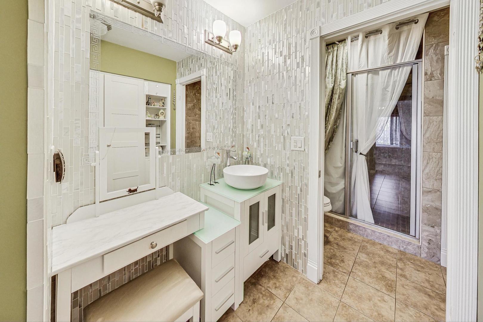 3900 Dundee Road, Unit 104 Northbrook, IL 60062 - Photo 21 of 34 a bathroom with a sink a mirror and a shower
