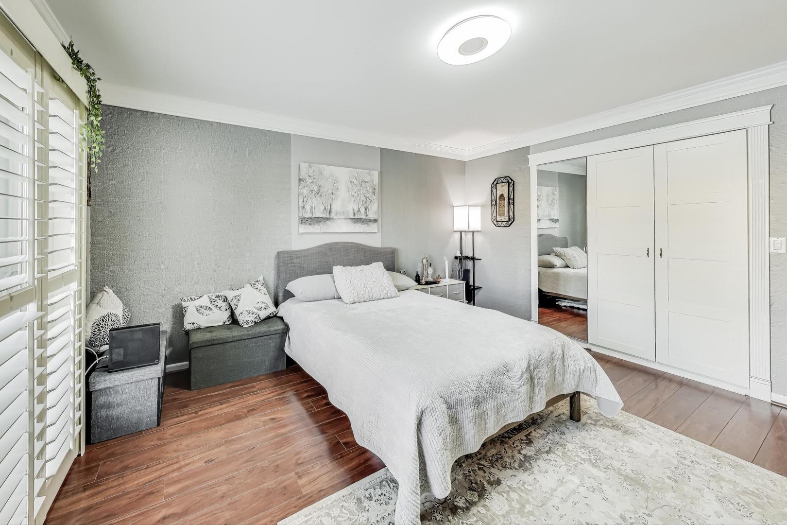 3900 Dundee Road, Unit 104 Northbrook, IL 60062 - Photo 22 of 34 a bedroom with a bed and wooden floor