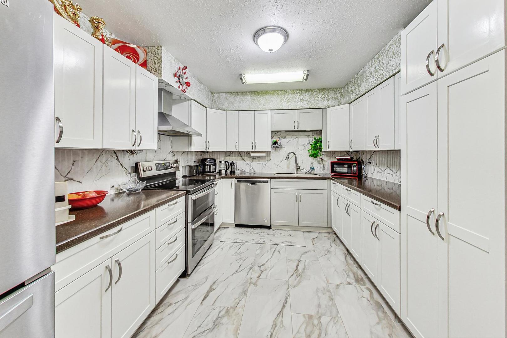 3900 Dundee Road, Unit 104 Northbrook, IL 60062 - Photo 8 of 34 a kitchen with granite countertop white cabinets and white appliances