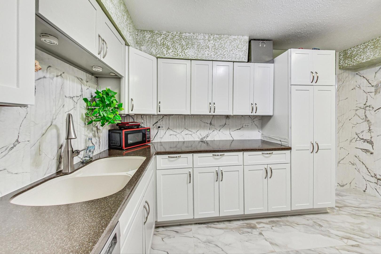 3900 Dundee Road, Unit 104 Northbrook, IL 60062 - Photo 9 of 34 a kitchen with granite countertop a sink a stove and cabinets