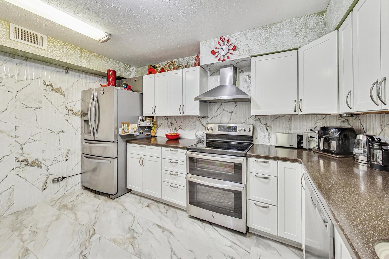 3900 Dundee Road, Unit 104 Northbrook, IL 60062 - Photo 10 of 34 a kitchen with cabinets appliances a sink and a counter top space