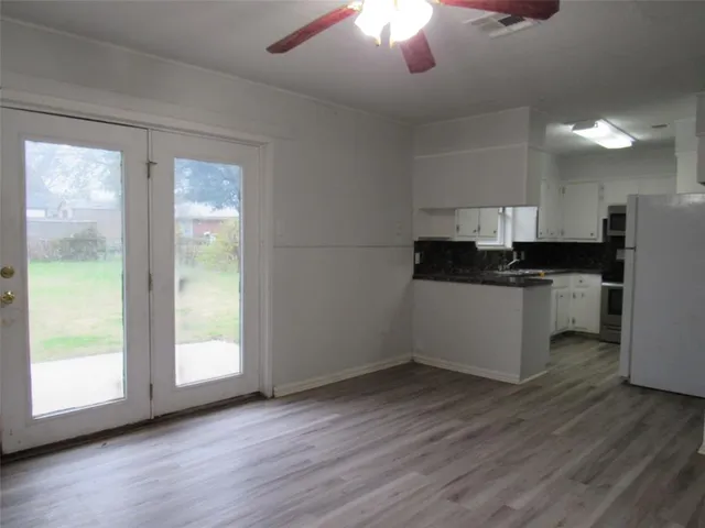 a kitchen with granite countertop a stove a sink and a refrigerator