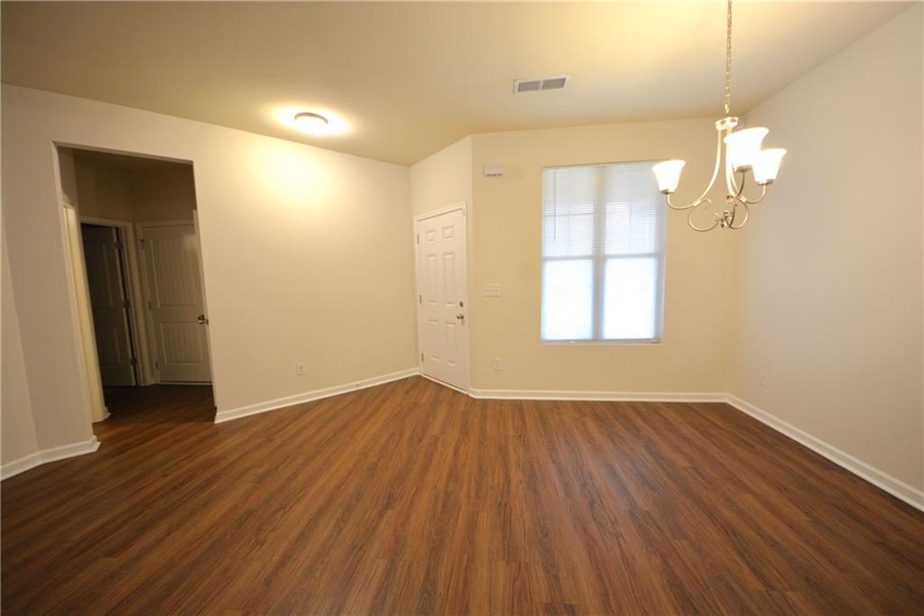 4305 Traipse Path Ellenwood, GA 30294 - Photo 12 of 36 an empty room with wooden floor and windows