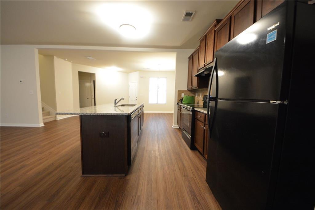 4305 Traipse Path Ellenwood, GA 30294 - Photo 19 of 36 a kitchen with stainless steel appliances a refrigerator a sink dishwasher and a stove with wooden floor