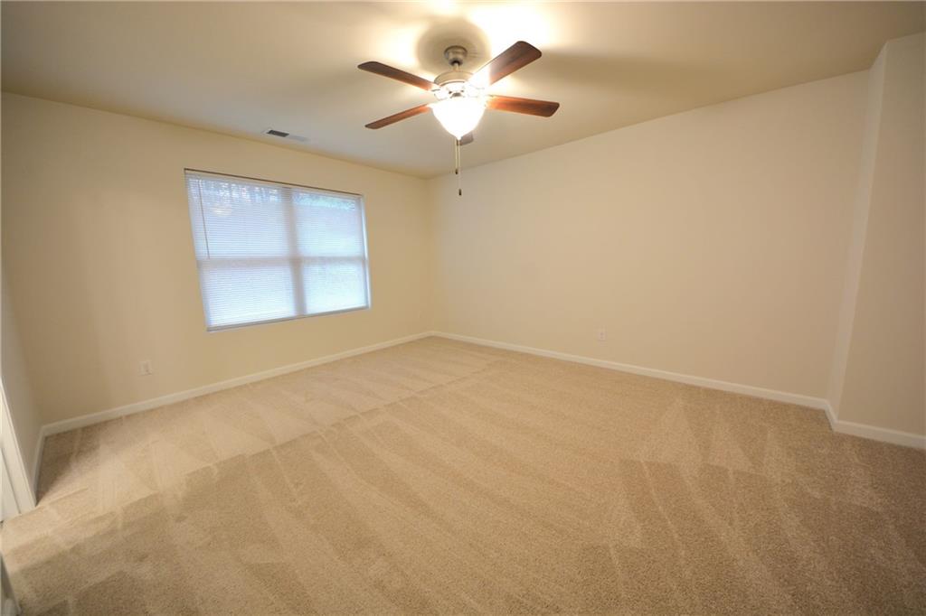 4305 Traipse Path Ellenwood, GA 30294 - Photo 24 of 36 an empty room with a chandelier fan and windows