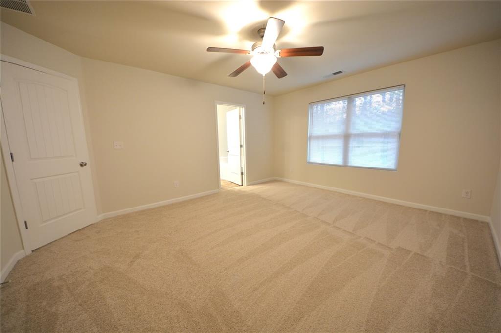 4305 Traipse Path Ellenwood, GA 30294 - Photo 25 of 36 an empty room with windows and ceiling fan
