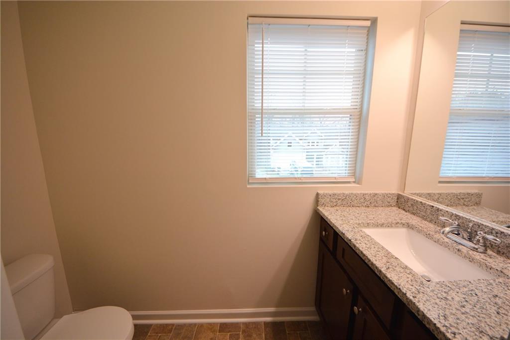 4305 Traipse Path Ellenwood, GA 30294 - Photo 33 of 36 a bathroom with a granite countertop sink toilet and a window