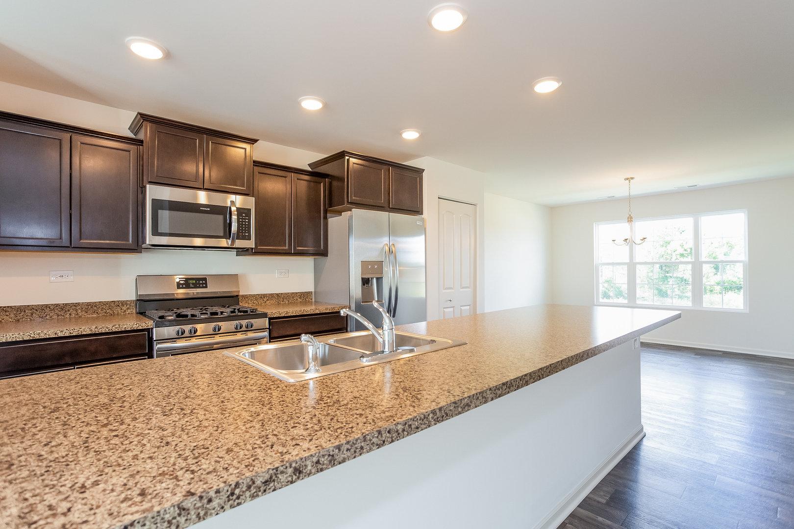 2407 Upland Road Pingree Grove, IL 60140 - Photo 2 of 19 a kitchen with stainless steel appliances granite countertop a sink a stove and a microwave