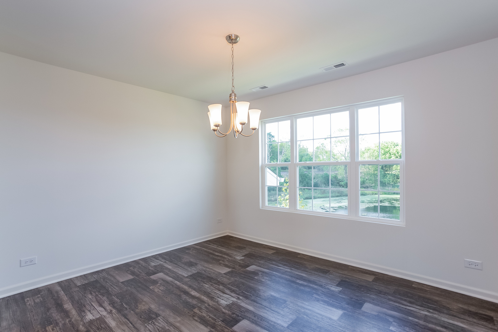 2407 Upland Road Pingree Grove, IL 60140 - Photo 7 of 19 a view of an empty room with wooden floor and a window