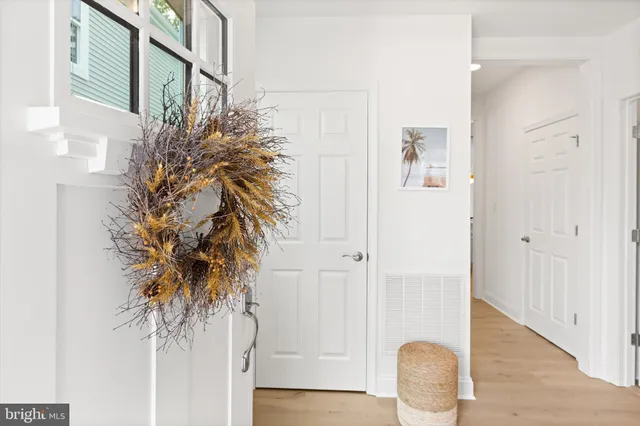 a view of a hallway with wooden floor and entryway