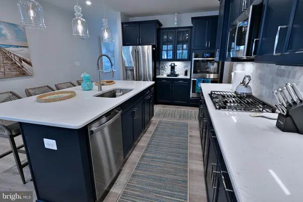 a kitchen with kitchen island stainless steel appliances a sink stove and cabinets