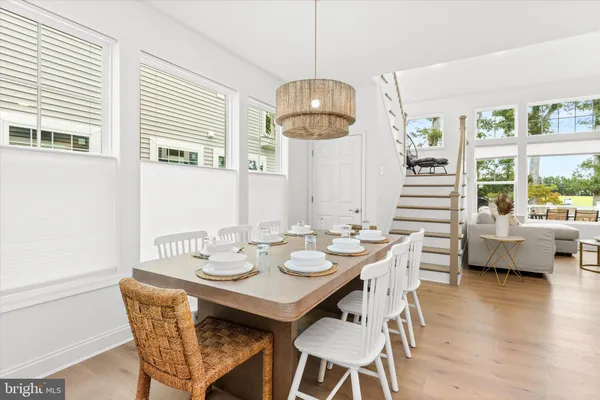 a dining room with furniture a chandelier and wooden floor