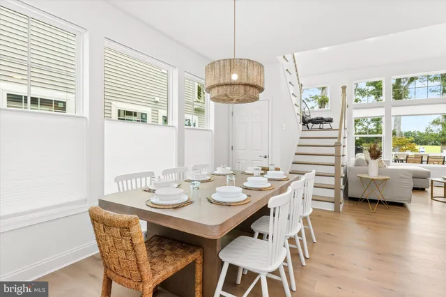 a dining room with furniture a chandelier and wooden floor