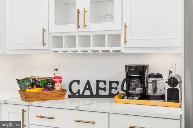 a kitchen with kitchen island a stove and a white cabinets