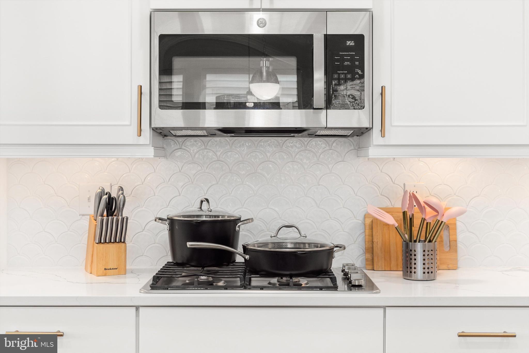 19277 American Holly Road Rehoboth Beach, DE 19971 - Photo 7 of 28 a kitchen with a stove and a microwave