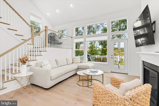 a living room with furniture a fireplace and a large window