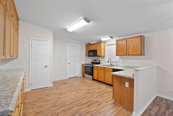a view of a kitchen with a sink a fireplace and window